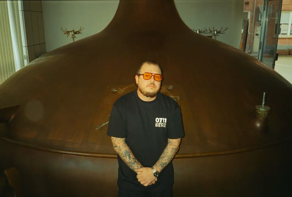 Person in schwarzem Shirt vor einem großen Braukessel