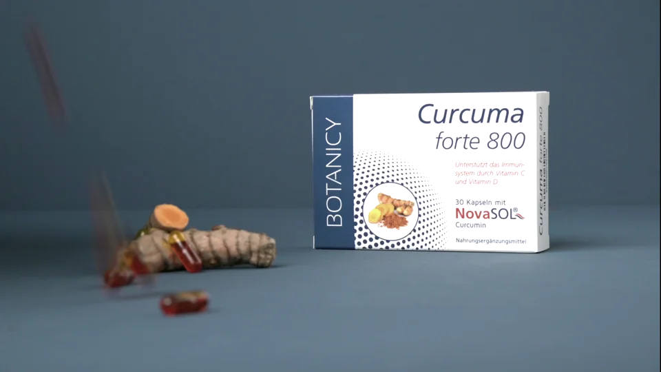Feelgood-Shop-Produktmotiv: Curcuma-Verpackung und Kurkumawurzel vor blauem Hintergrund