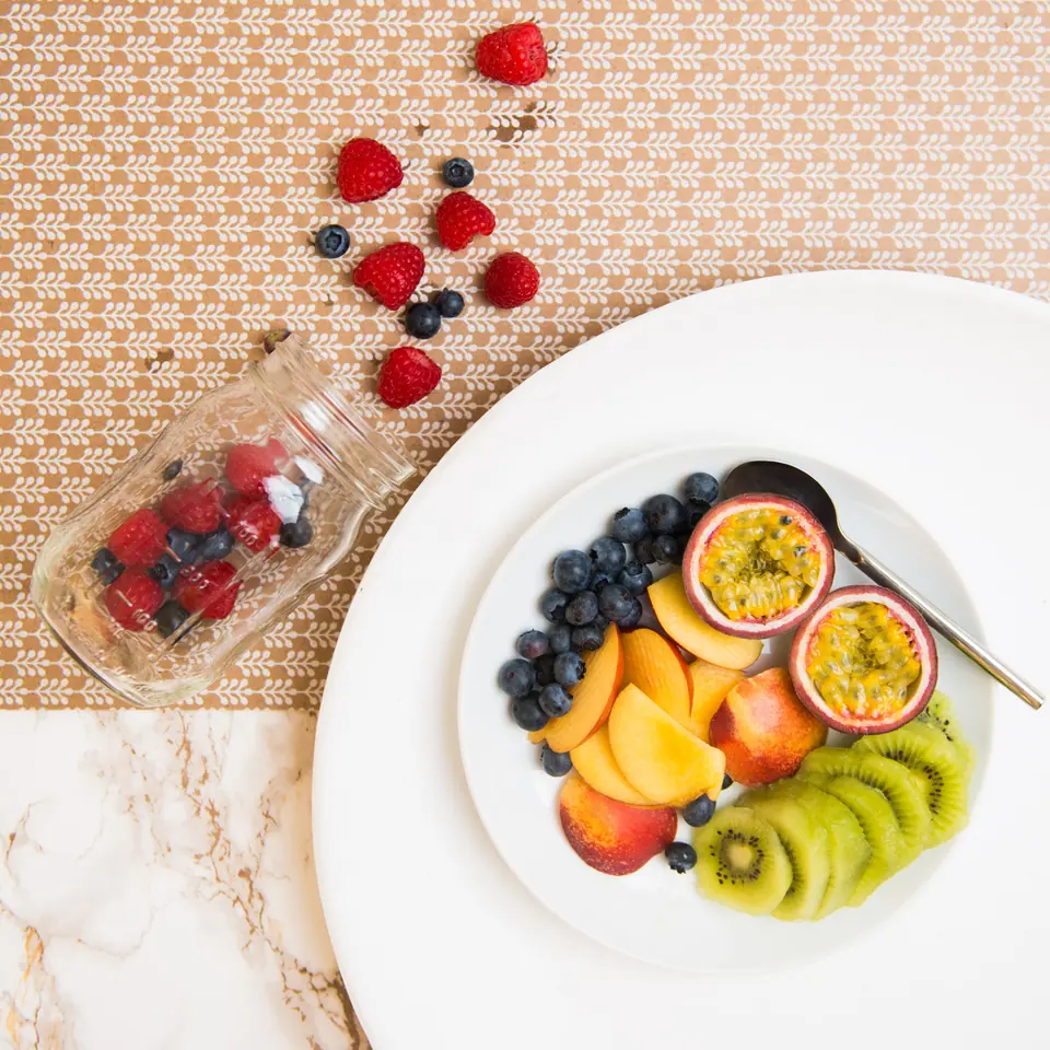 Teller mit Obst und Frühstück auf einer Tischdecke