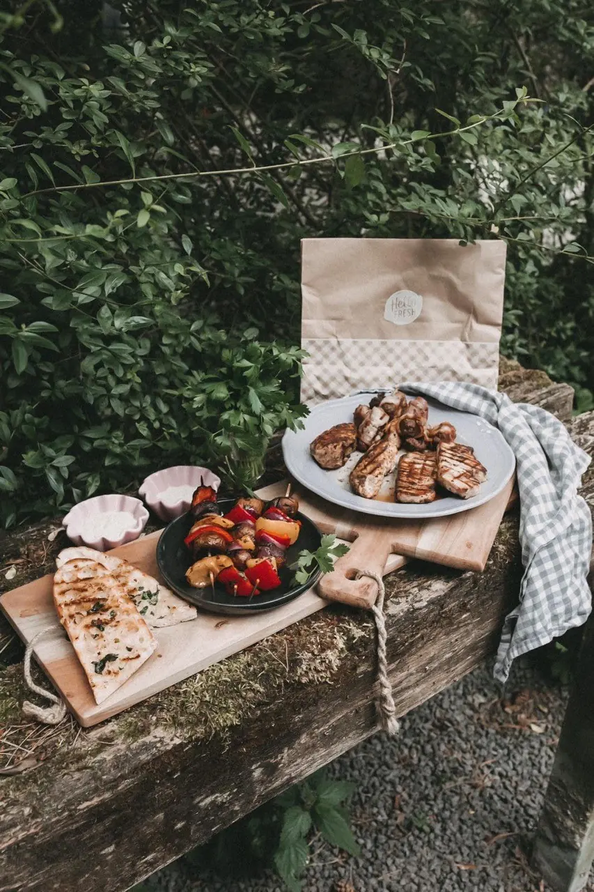 Fertige BBQ-Gerichte auf einem Tisch im Grünen