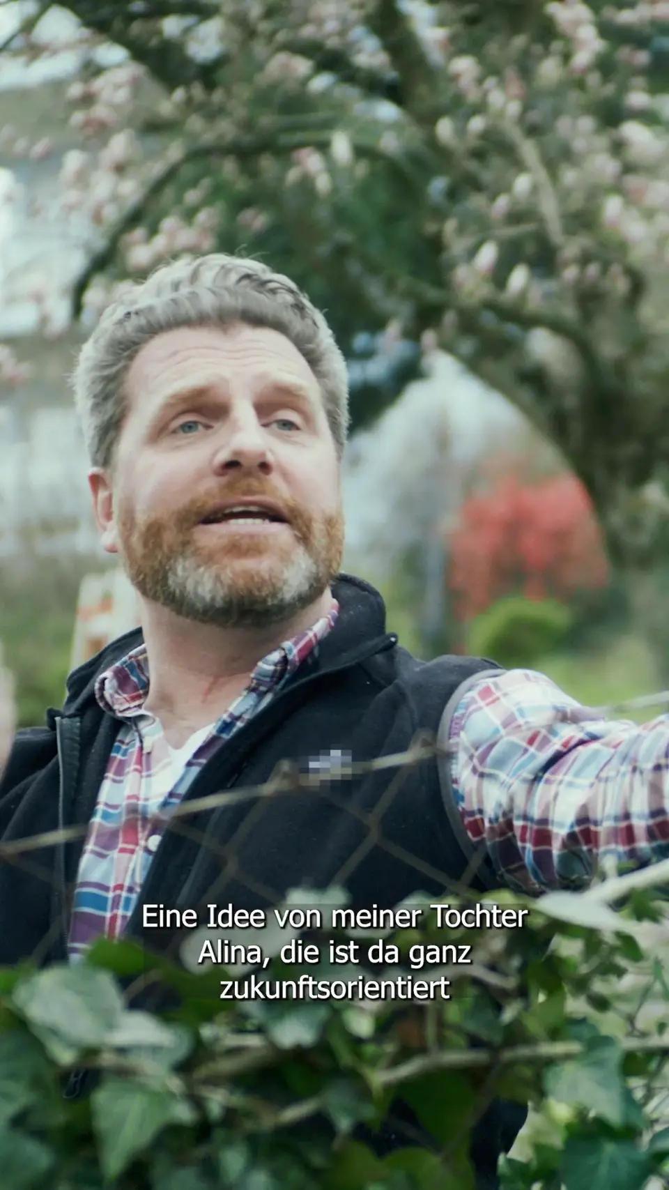 Protagonist blickt über eine Gartenhecke im Klimachen-Socialfilm