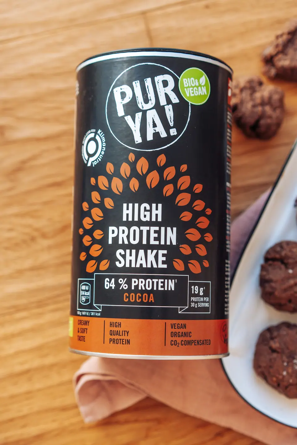 PURYA!-Proteinpackung auf einem Holztisch mit Rezeptkontext