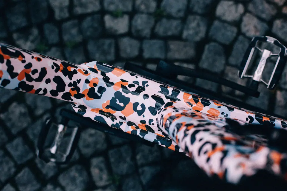 Fahrradrahmen mit auffälligem Leopardendesign auf Pflaster