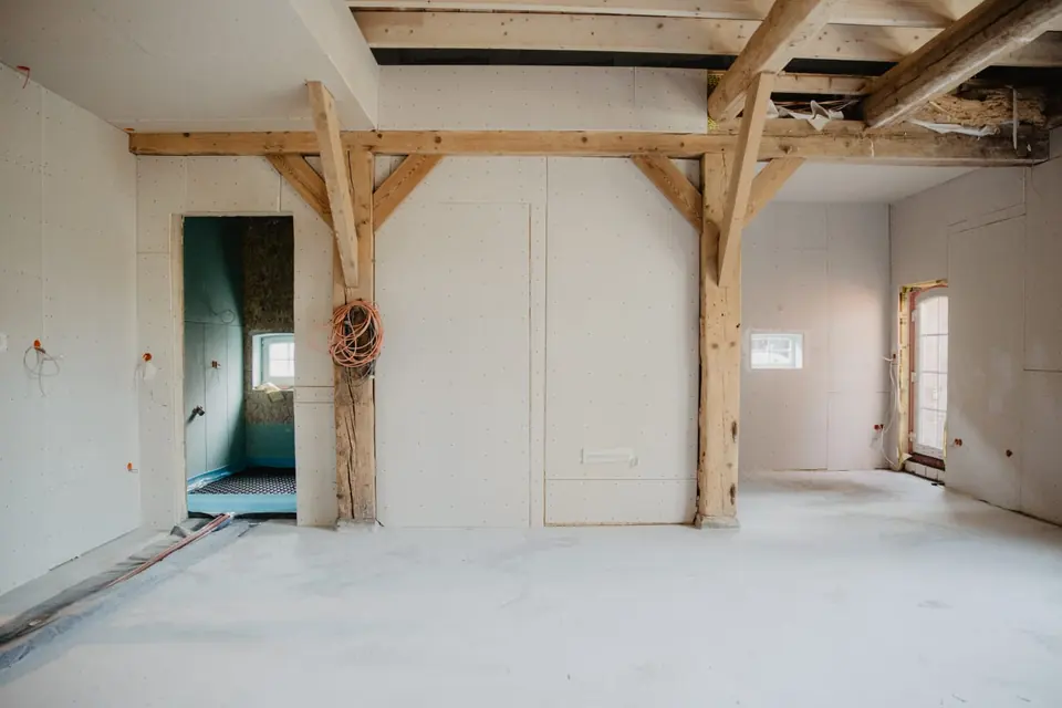 Unfertiger Wohnraum mit sichtbaren Holzbalken vor der DIY-Umsetzung